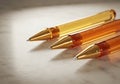Three golden transparent pens with pointed tips on light surface Royalty Free Stock Photo
