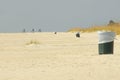 Three trash cans and three bike riders the beach