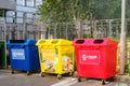 Three trash containers red, blue and yellow colors on a summer day. Bins for paper, plastic and glass waste