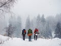 Three travelers in the winter forest walk along the trail in heavy snow Royalty Free Stock Photo