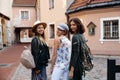 Three traveling girl friends with light backpacks walking exploring Riga city - Travel tourism concept after transfer