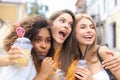 Three trendy cool hipster girls, friends drink cocktail in urban city background.