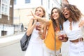 Three trendy cool hipster girls, friends drink cocktail in urban city background