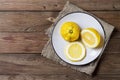 Three trendy ugly organic lemons on a white plate on a wooden natural painted background. Horizontal orientation.