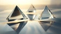 Three triangular glass objects are reflected in the water