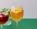 Three tropical mixed drinks, apple, mint, lime cocktails served on green and white background