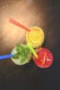 Three tropical mixed drinks with lime and lemon and mint leaves served in different glasses on rustic wooden table. Royalty Free Stock Photo