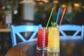 Three tropical mixed drinks with lime and lemon and mint leaves served in different glasses on rustic wooden table