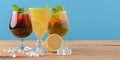 Three tropical mixed drinks with lime and lemon and mint leaves served in different glasses on rustic wooden table. Royalty Free Stock Photo