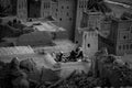 Three tuaregs talk in front of a house, black and white