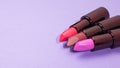 Three tubes of beautiful lipstick on a purple background Royalty Free Stock Photo