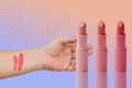 Three tubes of lipstick and two abstract strokes on the female hand of pink, natural color, sample color matching makeup, the Royalty Free Stock Photo