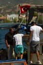 Three Turkish men are hopping on a fishing boat