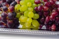 Three types of green, red and black grapes on a silver tray Royalty Free Stock Photo