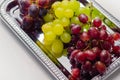 Three types of green, red and black grapes on a silver tray Royalty Free Stock Photo