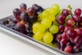Three types of green, red and black grapes on a silver tray Royalty Free Stock Photo