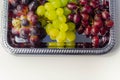 Three types of green, red and black grapes on a silver tray Royalty Free Stock Photo