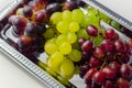 Three types of green, red and black grapes on a silver tray Royalty Free Stock Photo