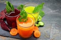 Three types of organic vegetable juice with ingredients on slate