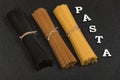 Three types of spaghetti on gray background and word Pasta. Italian cuisine