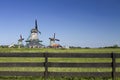 Three typical windmills and a wooden fence in Zaanse Schans, Netherlands Royalty Free Stock Photo