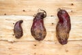 Three ugly beets lying on background of inverted tree bark.