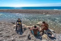 Three unidentified boys cleaning freshly caught fish on Playa Sana Rafael in Dominican Republic