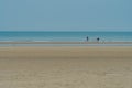 Three unidentified people walking on Chunjangdae beach