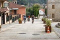 Three unknown cyclists riding up the hill in old town, Spain. Three friends on bikes at street in Europe. Active people concept.