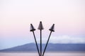 Three Unlit Light Torches on Kaanapali Beach, Maui with View of Lanai Island Royalty Free Stock Photo