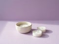 Three unscented white tea light candles arranged on a pastel purple surface with soft light Royalty Free Stock Photo