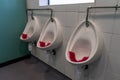 three urinals in a mens public bathroom or mens public toilet