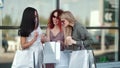 Three ÃÂurious fashion woman showing purchases looking shopping bag having positive emotion