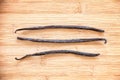 Three vanilla pods aligned on wood Royalty Free Stock Photo