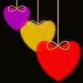 Three varicoloured fluffy hearts on a black background