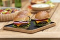 three vegan burgers on a wooden plate