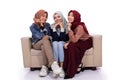 Three veiled women sitting on the couch while look at camera Royalty Free Stock Photo