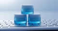 Three vibrant blue gel cubes stacked pyramid style on a computer keyboard Royalty Free Stock Photo