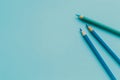 Three vibrant colored pencils rest upon a light blue canvas Royalty Free Stock Photo