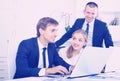 Three vigorous coworkers working on computers in company office Royalty Free Stock Photo