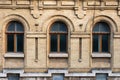 Three vintage arched windows in a wall of yellow bricks. Green - the colors of sea wave glass in a maroon dark red Royalty Free Stock Photo