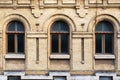 Three vintage arched windows in a wall of yellow bricks. Green - the colors of sea wave glass in a maroon dark red Royalty Free Stock Photo