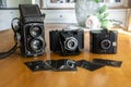 Three vintage cameras with photographic negatives