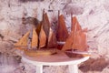 Three vintage handmade wooden sailboat replicas on white round table