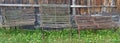 Three vintage iron rusty park benches stand near a wooden fence Royalty Free Stock Photo