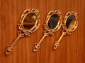 three vintage round golden hand mirrors crafted in bronze