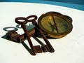 Three vintage, rusted iron keys and vintage brass navy compass.