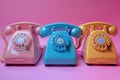 Three vintage telephones on pink background, reminiscent of a bygone era