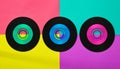 Three vinyl CD discs in flat lay format on a colorful background. Royalty Free Stock Photo