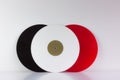 Three vinyls, black, red and white, on white background, with white space